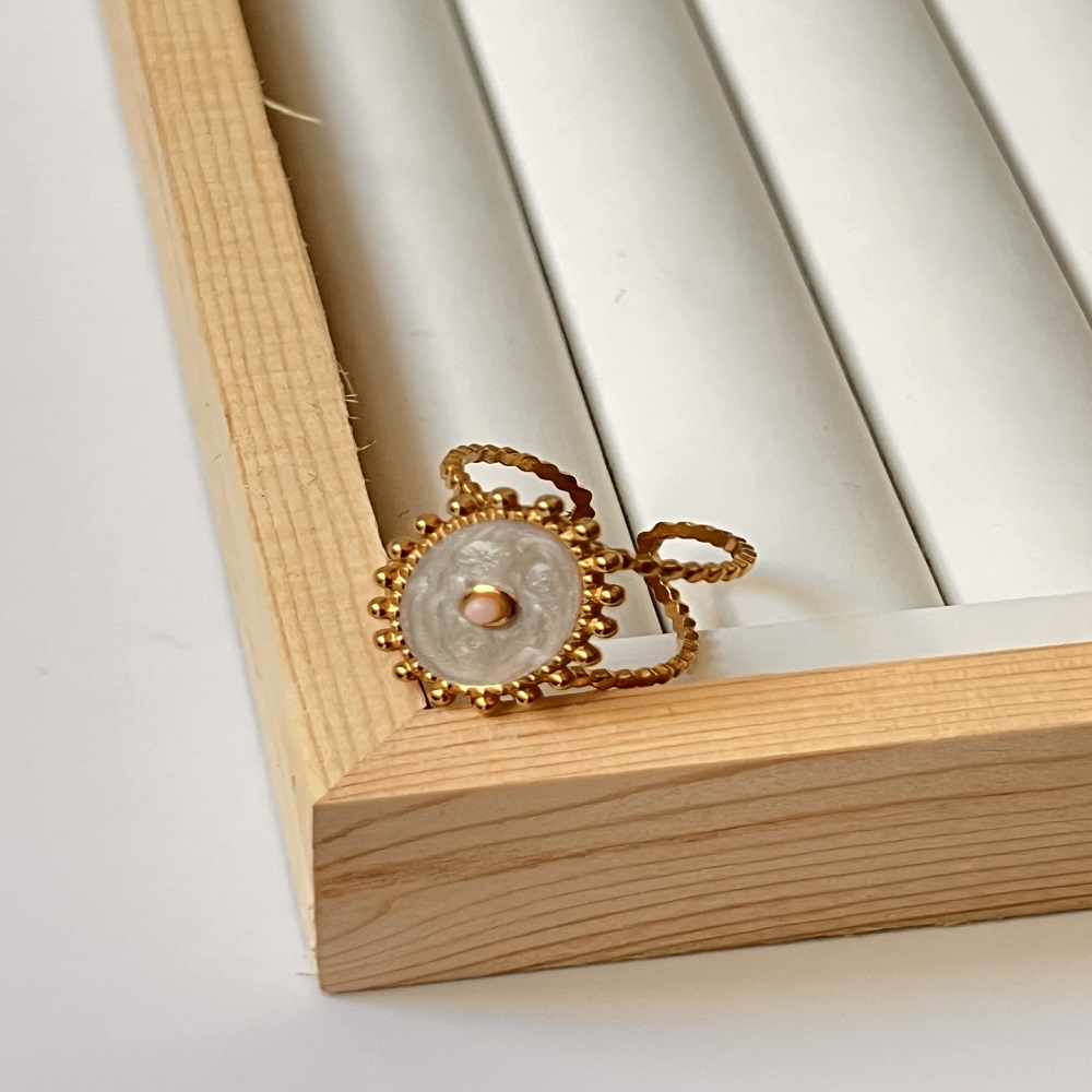 Δαχτυλίδι χρυσό με οβάλ σχέδιο από λευκό φιλντισι και απαλή ροζ πέτρα στο κέντρο